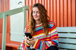 © Alba Vitta/Stocksy - Woman using phone outdoors