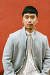 © Jimena Roquero/Stocksy - Elegant handsome man posing over red background looking at camera