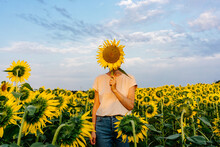 Person Covering Face With Sunflower
