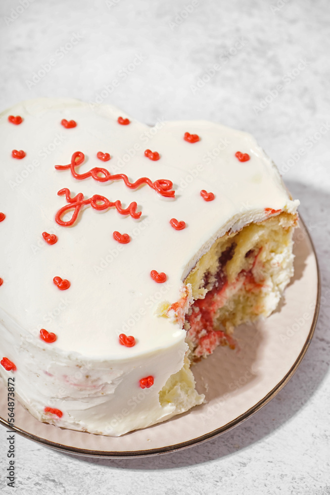 Plate with heart-shaped bento cake on white background. Valentine's Day celebration