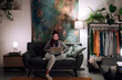 © Studio Marmellata/Stocksy - Young woman working on laptop in living room