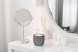 © Pixel Stories/Stocksy - Generic non-brand smart speaker on dressing table. Smart home concept.