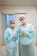 © AD Astra Team/Stocksy - The surgeon and the intern are standing in the operating room