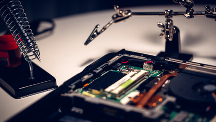 Wall Mural - a computer repairman solders a board on a laptop