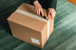 © Pixel Stories/Stocksy - Middle-aged adult woman opening clothing delivery box using cutter