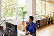 © ALTO IMAGES/Stocksy - Black woman talking on smartphone in office