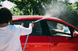 © ZQZ Studio/Stocksy - Young woman washing a red car