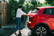 © ZQZ Studio/Stocksy - Young woman washing a red car