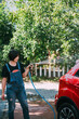 © ZQZ Studio/Stocksy - Young woman washing a red car