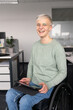 © Hernandez & Sorokina/Stocksy - Happy Woman In The Wheelchair At Office