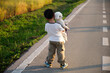 © ChaoShu Li/Stocksy - Asian little boy, playing with dog in rice field