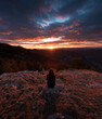 © Ibai Acevedo/Stocksy - Sitting woman enjoying winter mountain sunset