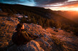 © Ibai Acevedo/Stocksy - Sitting hiker enjoying winter mountain view at sunset