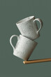 © Giada Canu/Stocksy - mugs balancing on a wooden stick