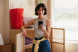© BONNINSTUDIO/Stocksy - Happy woman with smartphone in new apartment
