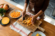 © Momento Estudio/Stocksy - senior woman cutting  fresh pumpkin