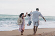 © Anastasia Mihaylova (Shpara)/Stocksy - Family Holding Hands Together With Child On Beach Near Ocean in summer