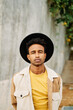 © nomad studio/Stocksy - Young man with hat posing outdoors.