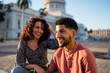 © Daniel Gonzalez/Stocksy - Cheerful couple sitting on pavement