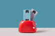 © Yaroslav Danylchenko/Stocksy - Red retro toaster with two VHS cassettes.