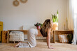 © Eloisa Ramos/Stocksy - Young woman practicing yoga postures at home
