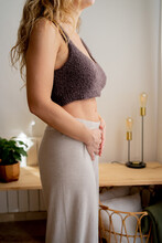 Cropped Woman Touching Her Belly At Home