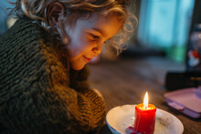 Kid Looking At Red Candle Burning