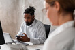 © Aleksandra Jankovic/Stocksy - Black Businessman Using Phone In The Office