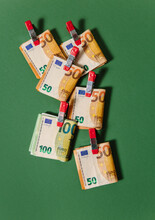 50 And 100 Euro Notes Clipped Together On A Green Background