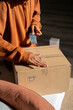 © Alba Vitta/Stocksy - Man packing delivery online purchase
