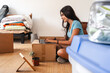 © Luis Herrera/Stocksy - woman sitting on the floor using her laptop after home moving