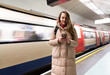 © Hernandez & Sorokina/Stocksy - Woman Using Phone In Subway Terminal