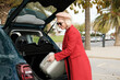 © Malquerida Studio/Stocksy - Traveler woman taking luggage from car