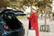 © Malquerida Studio/Stocksy - Tourist woman taking luggage from car