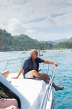 Man Sitting On Boat Enjoying View