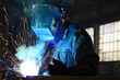 © Максим Халанский - Workers wearing industrial uniforms and Welded Iron Mask at Steel welding plants, industrial safety first