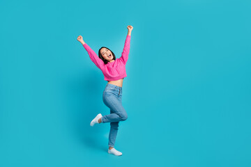 Poster - Full body portrait of ecstatic positive indonesian lady raise fists success empty space isolated on blue color background