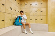 © Javier Díez/Stocksy - Cheerful sportswoman opening backpack in dressing room