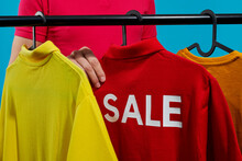 Man Grabbing A Red T-shirt With The Word Sale