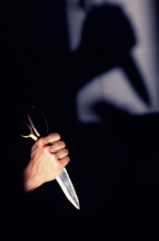 Hand And Silhouette Of A Hand Holding Scissors As A Weapon.