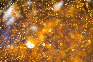 Wall Mural - Abstract Golden bokeh background. Defocused Golden Particles Glittery in Motion Blur Particles. Gold Sequins and Bokeh. Defocused lights dots.