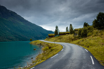 Wall Mural - Wooden rorbus, typical houses with grass on the roof, on the Lovatnet Lake,  Norway