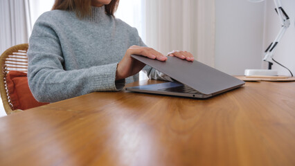 Wall Mural - closeup image of hands close and open a laptop computer on table after finished using it