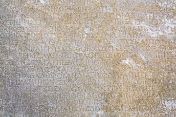 fragment of ancient greek inscription, carved on marble block at the archaeological site of ephesus.