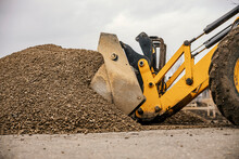 Cropped Picture Of A Bulldozer Working With Gravel On Construction Site.