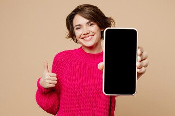 young happy fun woman wear pink sweater hold use close up mobile cell phone with blank screen worksp