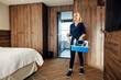 © Dusan Petkovic - A happy maid is walking in hotel room with basket full with cleaning products and preparing to cleanup it.