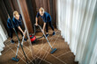 © Dusan Petkovic - Top view of a maid vacuuming floor in a hotel room.