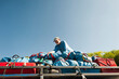 © Cavan Images - Low angle view of happy senior man adjusting luggage on vehicle roof against clear sky during summer