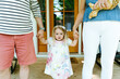 © Cavan Images - Cropped closeup of a toddler girl holding her parents hands